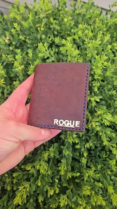 Oxblood bifold with the gold ROGUE stamp, out in the garden — Rogue Artisan, East Vancouver